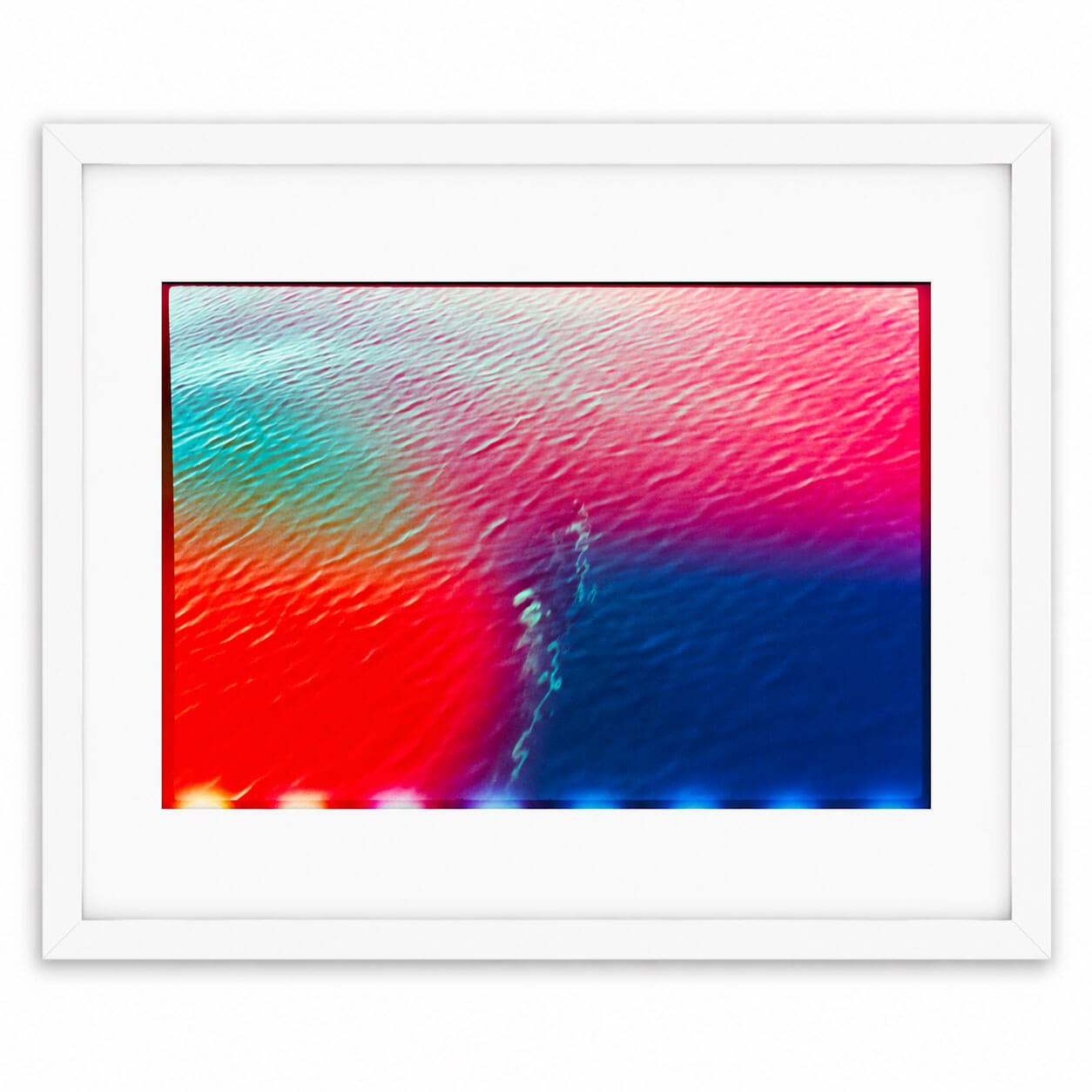 A framed abstract art print featuring a vibrant color gradient of red, pink, teal, and blue with textured, rippling patterns, presented in a white frame with a white mat against a clean white background.