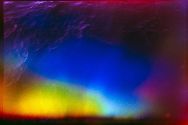 Abstract colorful photograph with a large blue central area, purple and magenta edges, and yellow light near the bottom, with no clearly identifiable physical product or packaging.